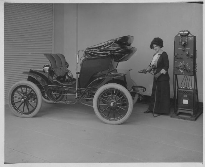 Woman with rectifier and electric car (1912)